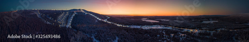 A panoramic drone shot of the ski slopes of Levi ski resort at sunrise  Kittil    Finland. A wintery landscape in Finnish Lapland. 