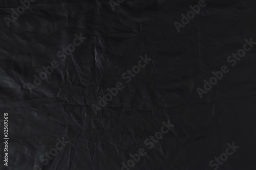 Crumpled black fabric cloth texture.  Abstract elegant textured textile background for design. Close up. Flat lay. View from above.