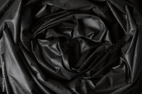 Texture of luxury black round waved fold silk satin textile material. Abstract elegant cloth background for design. Close up. Flat lay. View from above.