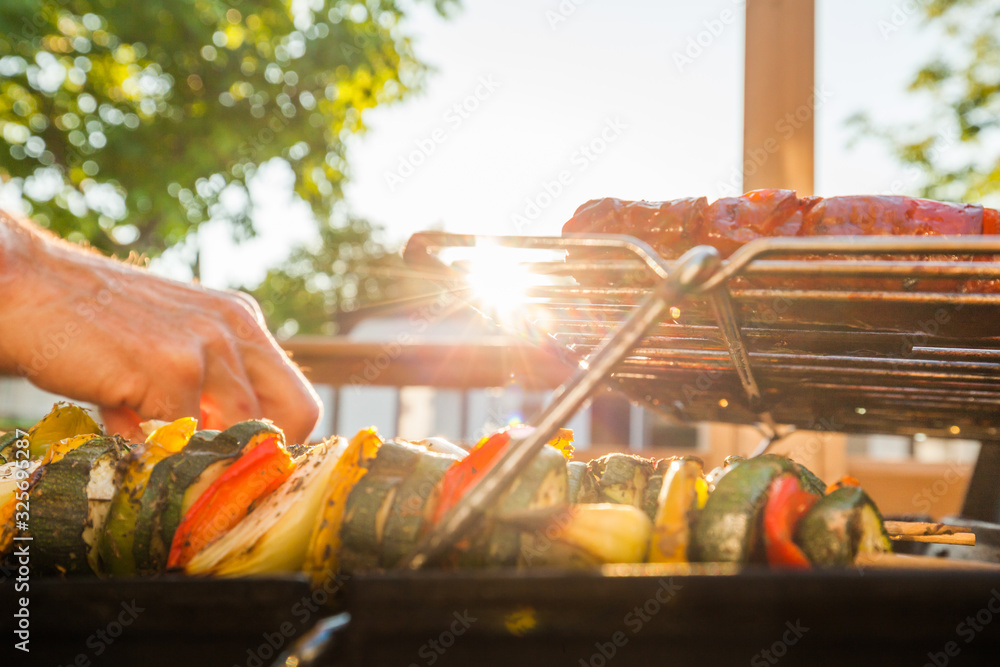 Grilling meat outdoors during a weekend rest - obrazy, fototapety, plakaty 