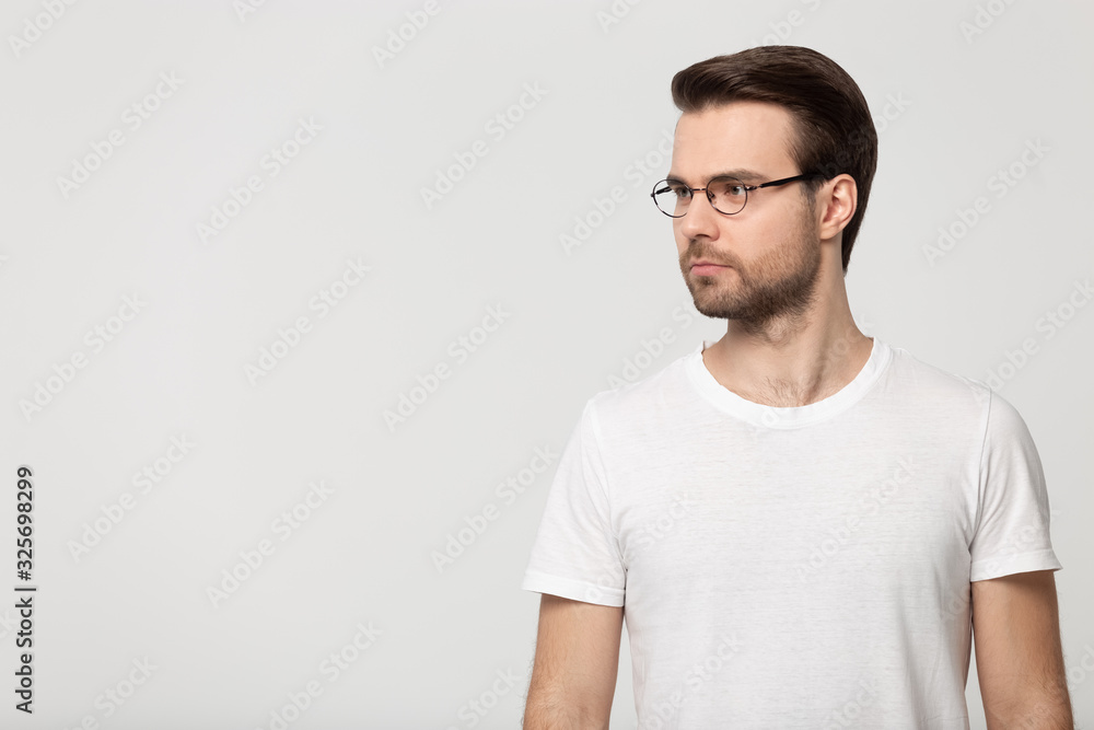 Fototapeta premium Serious concentrated young guy standing aside free copy space.