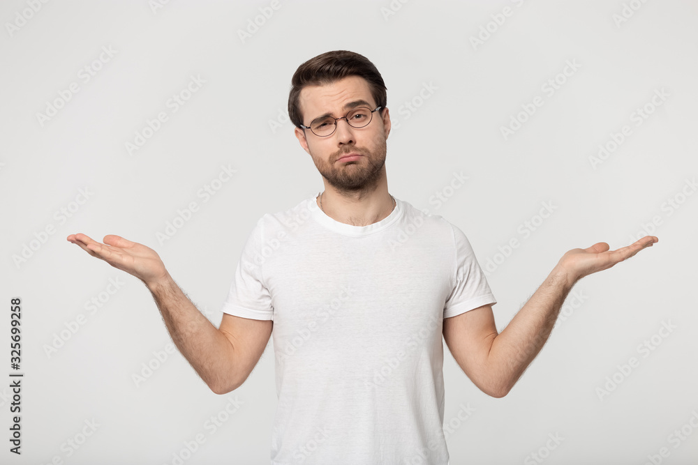 Doubtful young man demonstrating empty copy spaces for advertising products. Doubtful young man demonstrating empty copy spaces for advertising products.