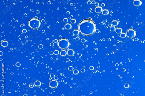 Large beautiful Oxygen bubbles underwater on a blue background macro. 