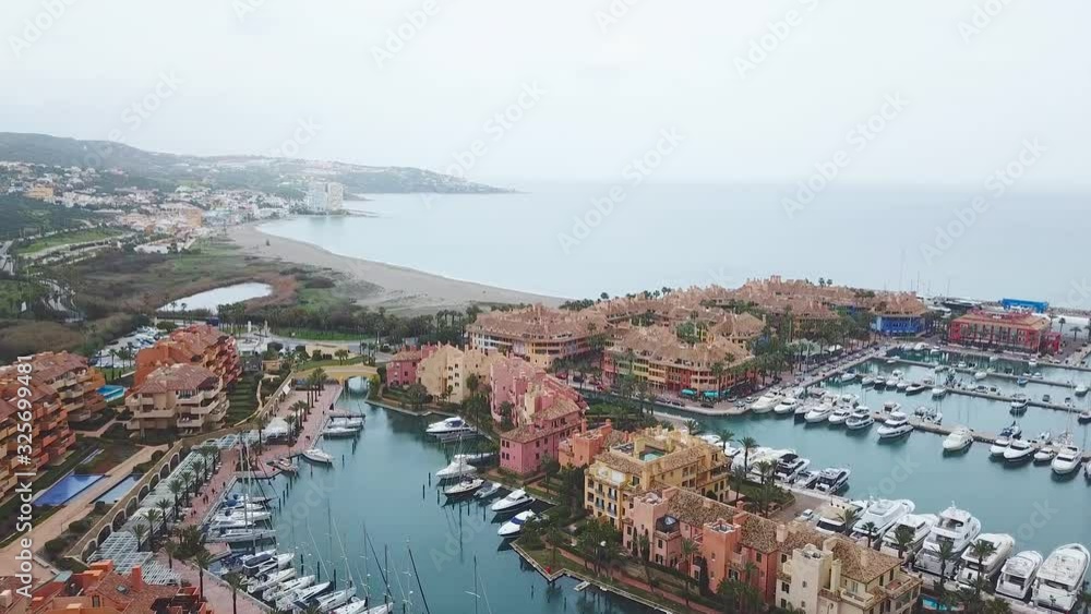 Unique generic aerial view of exclusive Sotogrande Bay - Costa del Sol. Cloudy day and rainy , beautiful sky colours. Luxury real estate and yacht. Famous location. Unique generic aerial view of exclusive Sotogrande Bay - Costa del Sol. Cloudy day and rainy , beautiful sky colours. Luxury real estate and yacht. Famous location.