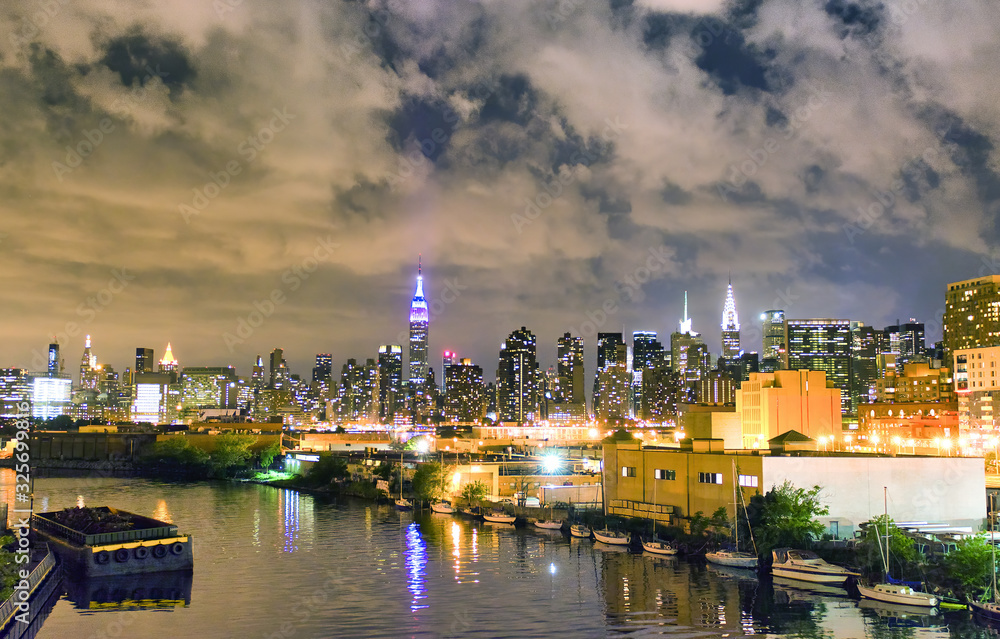 Night view of Midtown Manhattan panoramic skyline with East River, New York City