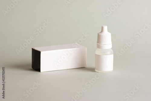 Isolated eye drop bottle on grey background.