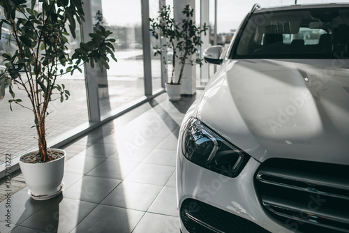 Part of white car in shop, spotlight