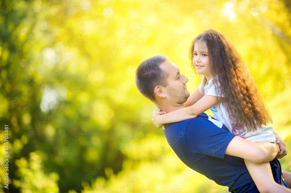 Happy family. Dad with his beloved daughter in his arms in the park at sunset, family time. Happy family. Dad with his beloved daughter in his arms in the park at sunset, family time.