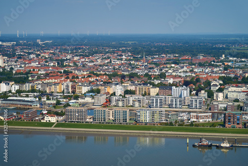 Bremerhaven, Germany - August 25, 2019: aerial view of the city with new apartment houses round the port "Neuer Hafen" (new harbor) on a sunny summer day seen from the river Weser