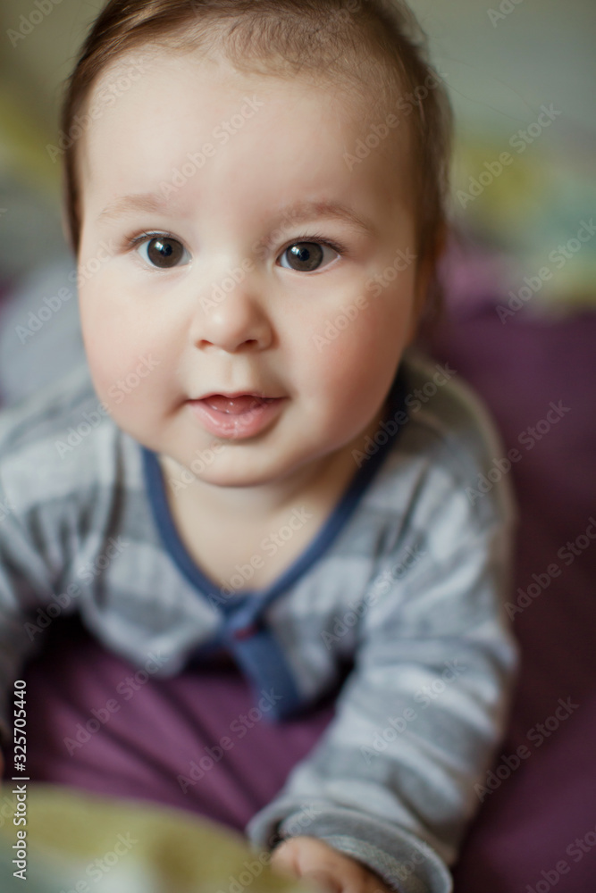 Cute baby boy in grey cloth