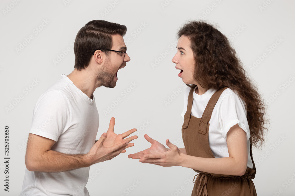 Aggressive stressed young couple arguing in front of each other. Aggressive stressed young couple arguing in front of each other.