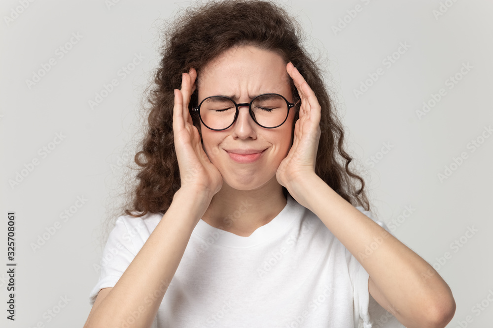 Stressed young girl in eyeglasses suffering from strong head ache. Stressed young girl in eyeglasses suffering from strong head ache.