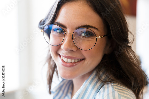 Close up of an attractive brunette woman wearing glasses