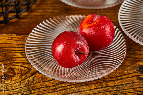 Red plums in a glass fruit plate