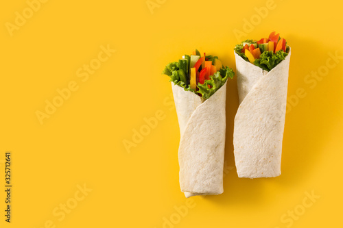 Vegetable tortilla wraps on yellow background. Top view. Copy space
