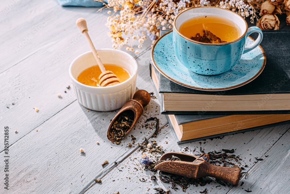 tea and a book in the spring sunshine. near honey and flowers