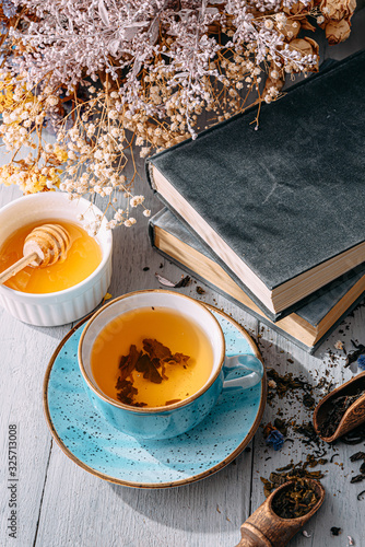 tea and a book in the spring sunshine. near honey and flowers