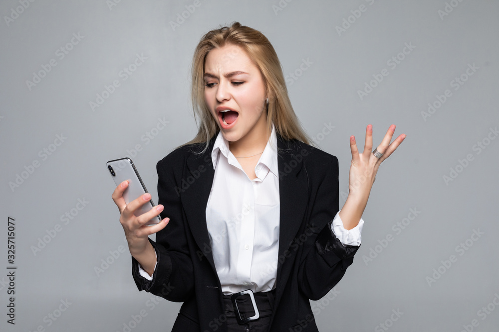 Surprised pretty businesswoman chatting by phone standing isolated over white background. Surprised pretty businesswoman chatting by phone standing isolated over white background.