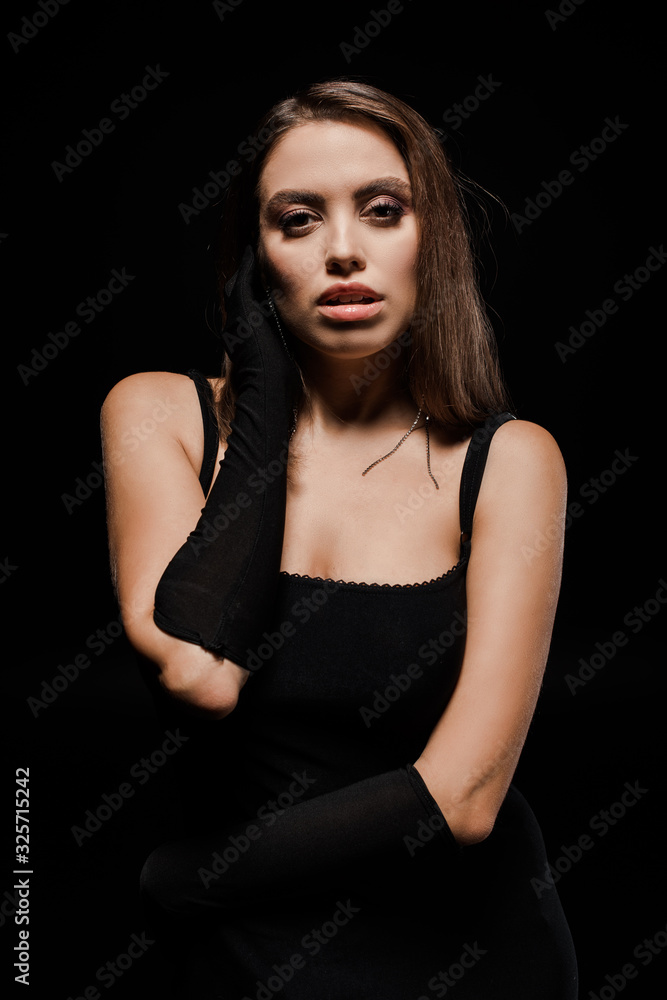 attractive woman in gloves looking at camera isolated on black attractive woman in gloves looking at camera isolated on black
