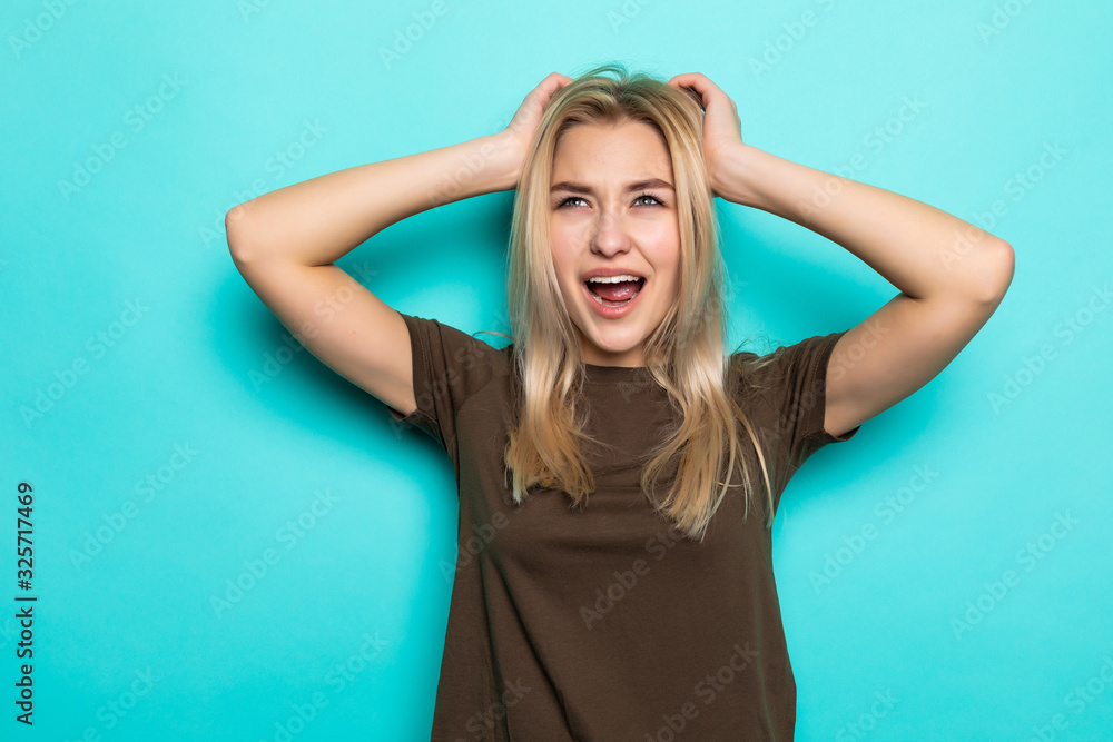 Surprised young pretty girl looking at the camera isolated on the blue background