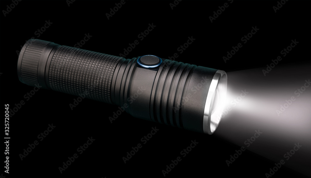Fototapeta premium Battery powered flashlight on black background with copy space