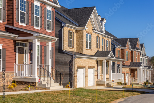 Luxury single family homes covered with brick, or vinyl sidings, covered entrances, two car garage on a newly constructed high end residential community street in Maryland USA