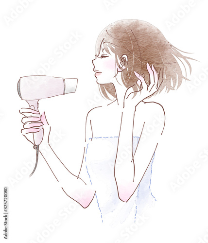 ドライヤーでボブヘアを乾かす若い女性