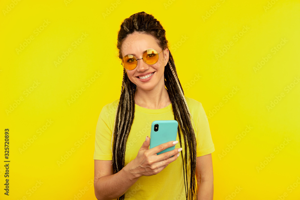 Happy smiling woman with bright phone in the yellow studio Happy smiling woman with bright phone in the yellow studio