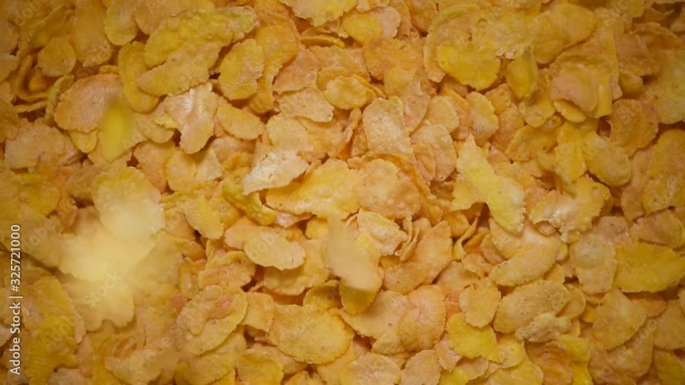 Golden corn flakes for breakfast on rotating background. Food ingredient background. Top view, healthy lifestyle concept. Vegan healthy nutrition Golden corn flakes for breakfast on rotating background. Food ingredient background. Top view, healthy lifestyle concept. Vegan healthy nutrition