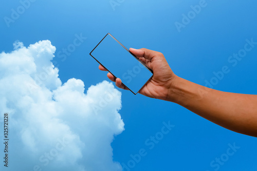 Smart phone  in hand on blue sky background