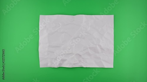 Stop motion VDO, paper ball unwrapping on green background.