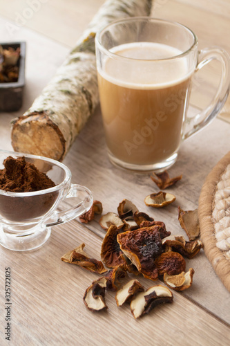 Coffee latte mushroom trend, birch mushroom chaga, dried cep boletus, branch of birch and coffee powder, vertical image