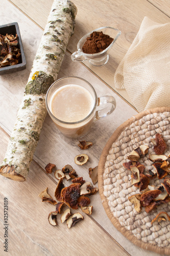 Concept of trend modern food industry. Mushroom coffee latte from mushrooms Chaga and cep, Vertical image on a wooden light background