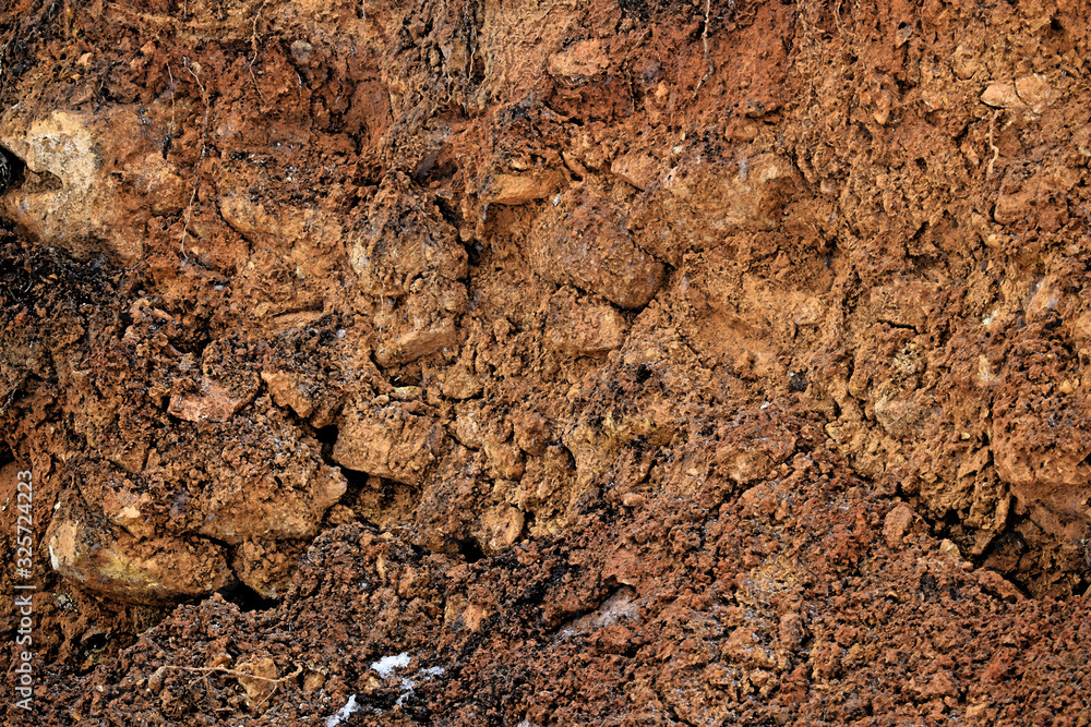 Brown abstract background.Clay surface with stones.