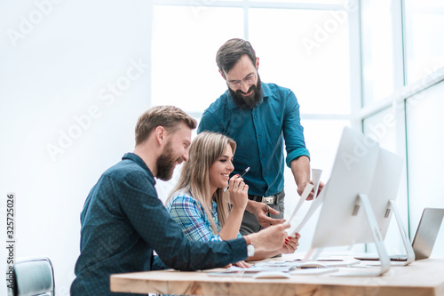 smiling employees checking financial statements . business concept photo