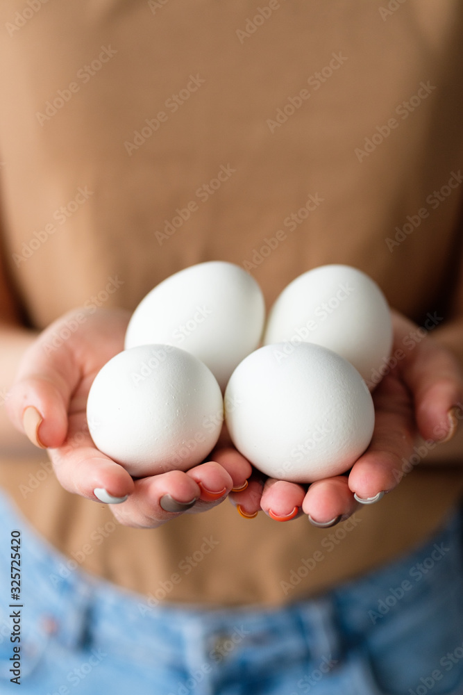 Female hands holding several white eggs Female hands holding several white eggs