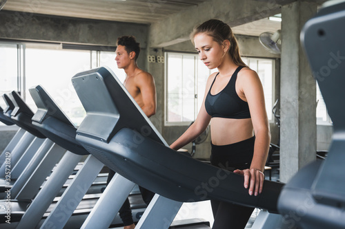 Young couple Exercising by running on the treadmill To maintain good health always