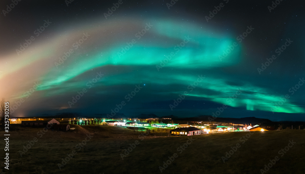 A high resolution panorama of aurora borealis also known as a northern lights above one of the Icelandic villages. Beautiful and magical arctic weather conditions. Tourism in Iceland