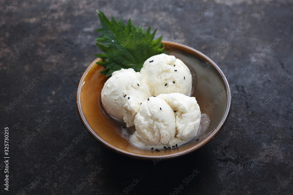 Scoops of coconut ice cream. Dessert in a bowl on a dark background. Scoops of coconut ice cream. Dessert in a bowl on a dark background.