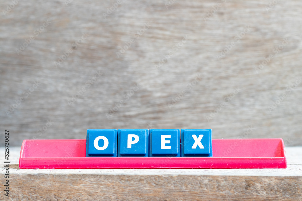 Tile letter on red rack in word opex (abbreviation of operating expense) on wood background