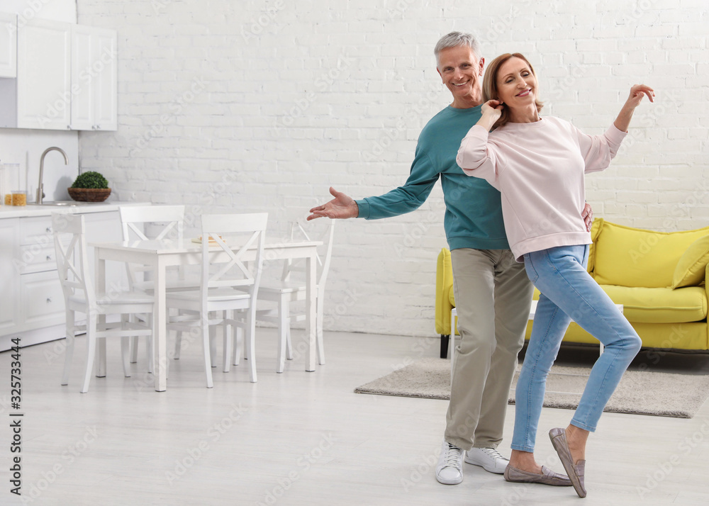 Happy senior couple dancing together in kitchen Happy senior couple dancing together in kitchen