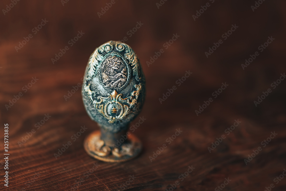 vinage Easter egg decorated with papier-mache hand made, beautiful decorations on egg at stand, picture of woman with bird on egg, on wooden background. vinage Easter egg decorated with papier-mache hand made, beautiful decorations on egg at stand, picture of woman with bird on egg, on wooden background.