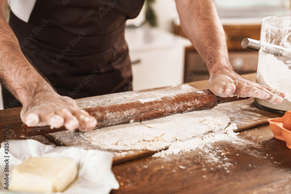 Cropped image of caucasian man in apron cooking dough Cropped image of caucasian man in apron cooking dough