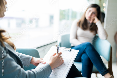 Therapist Making Notes During Session With Patient photo
