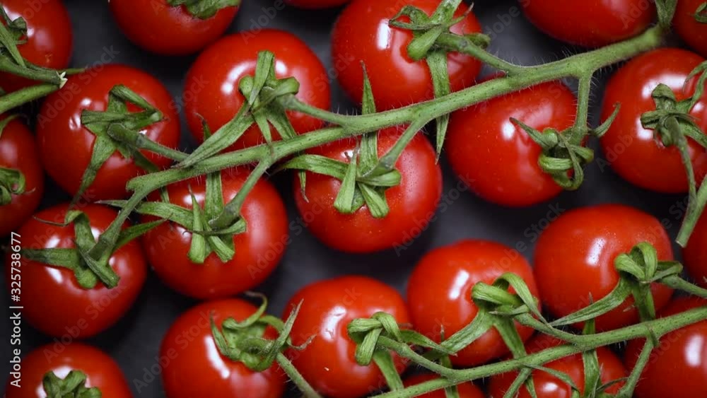 Cherry tomatoes on rotating background. Top view. Vegan and raw food concept. Bunch of fresh red tomatoes Cherry tomatoes on rotating background. Top view. Vegan and raw food concept. Bunch of fresh red tomatoes