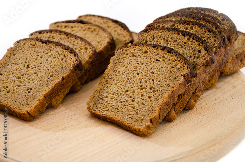 Sliced rye bread on a cutting board. Isolated on white. Delicious, brown bread.