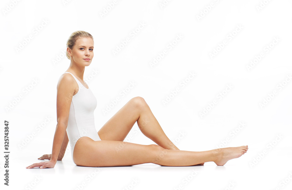 Young, beautiful, slim and healthy blond girl in white swimsuit applying skincare cream. Massage, skincare, healthcare, wrinkles removal and fitness. Young, beautiful, slim and healthy blond girl in white swimsuit applying skincare cream. Massage, skincare, healthcare, wrinkles removal and fitness.