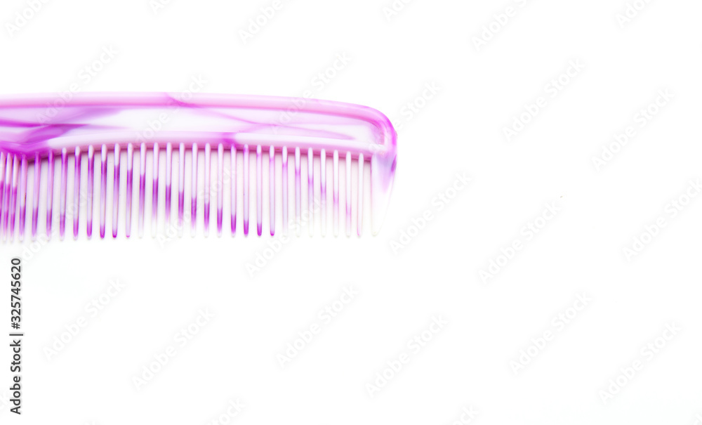 White and pink plastic hair comb with small and large teeth on a white isolated background. Comb for the head. Abstraction White and pink plastic hair comb with small and large teeth on a white isolated background. Comb for the head. Abstraction