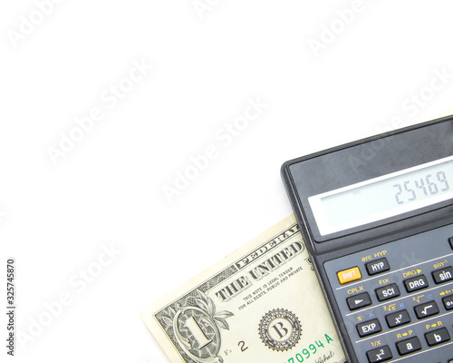A black engineering calculator (not completely, but part) with gray buttons and a banknote of one American dollar under it. White isolated background. Accounting for finance and budget.
