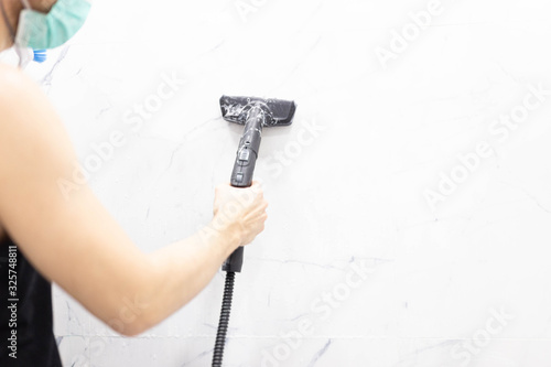 cleaning the house with a steam cleaner, cleaning the walls of ceramic tiles. photo